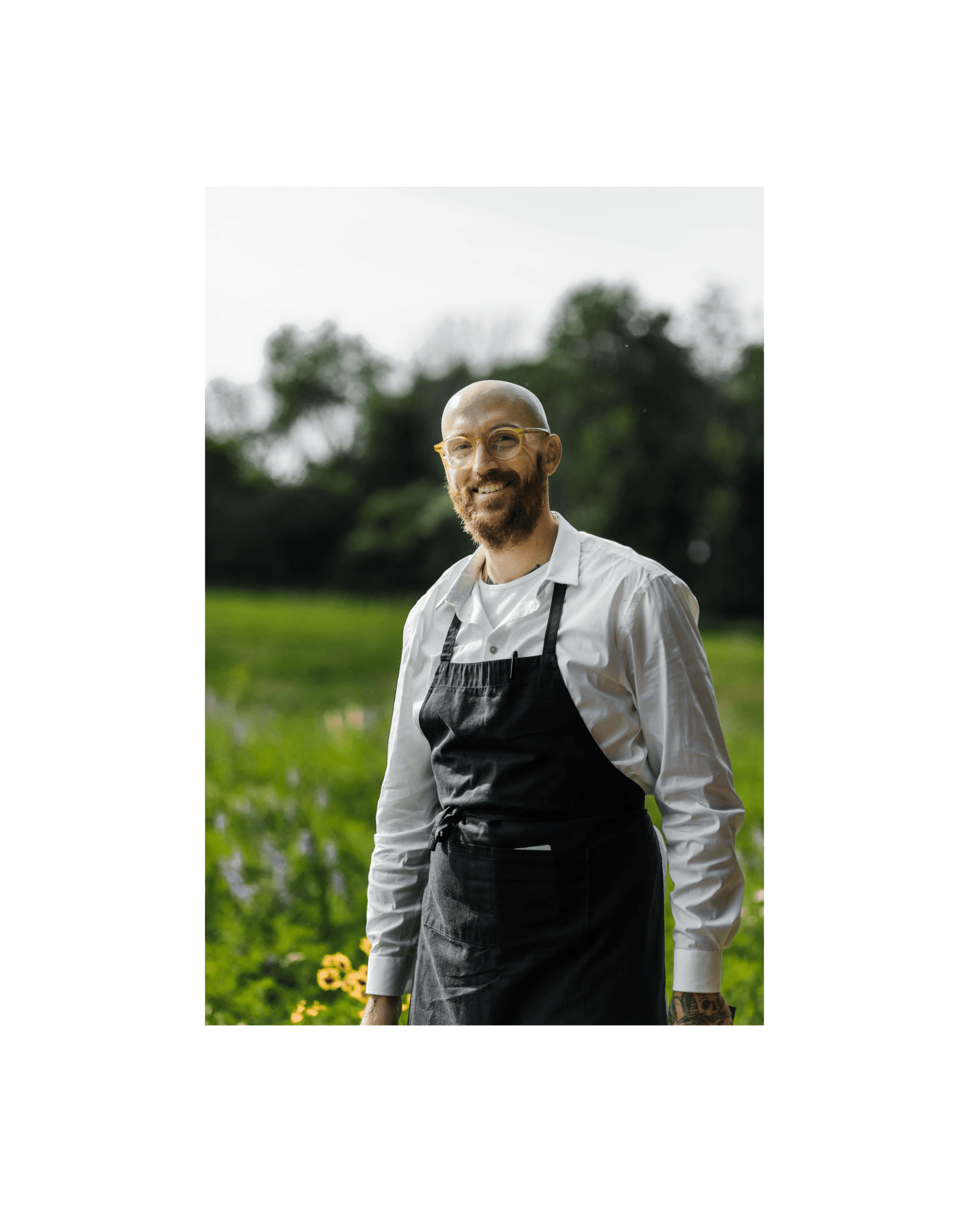 chef Matthew Ravenscroft smiling in front of a field