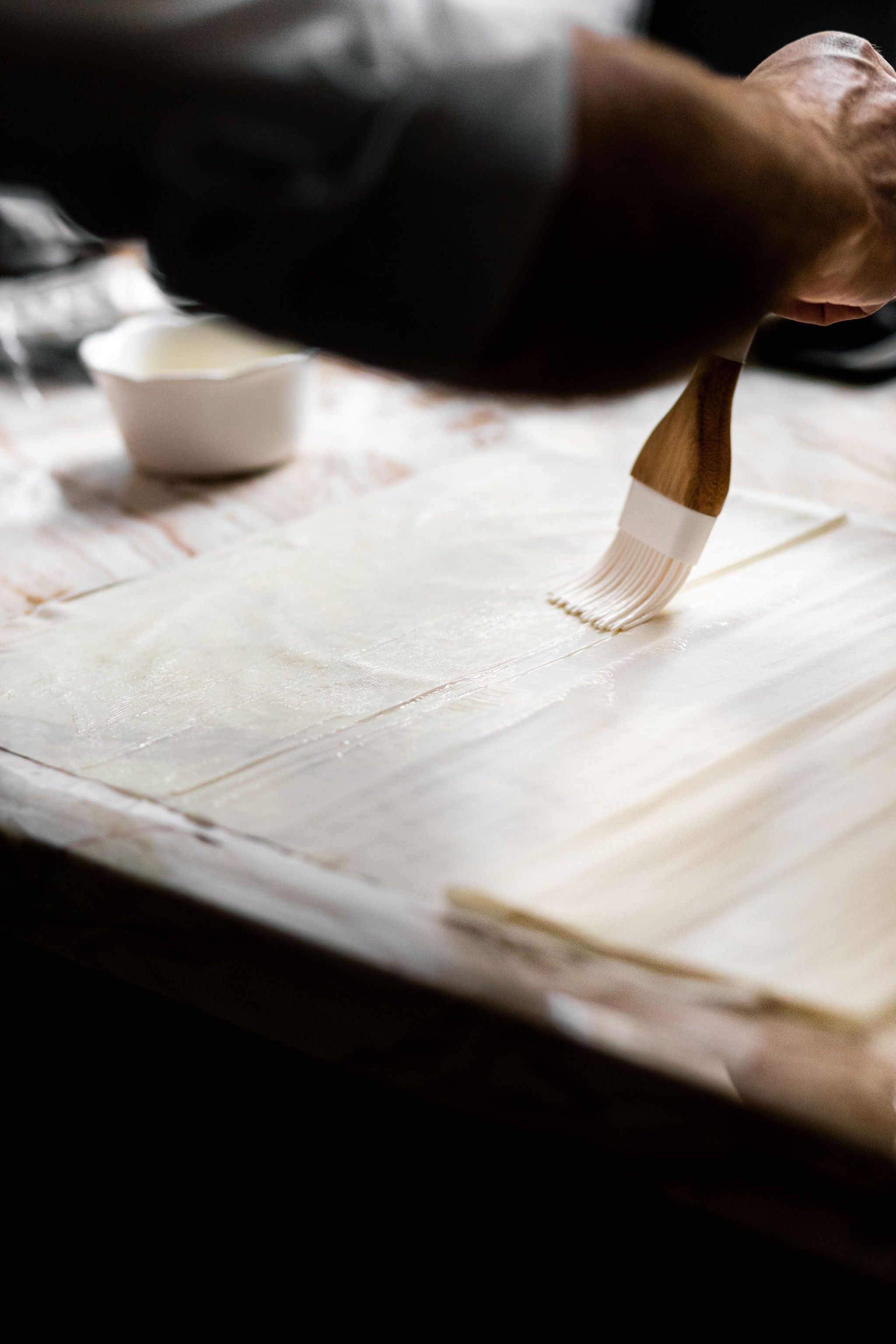 closeup of chef brushing pastry with butter
