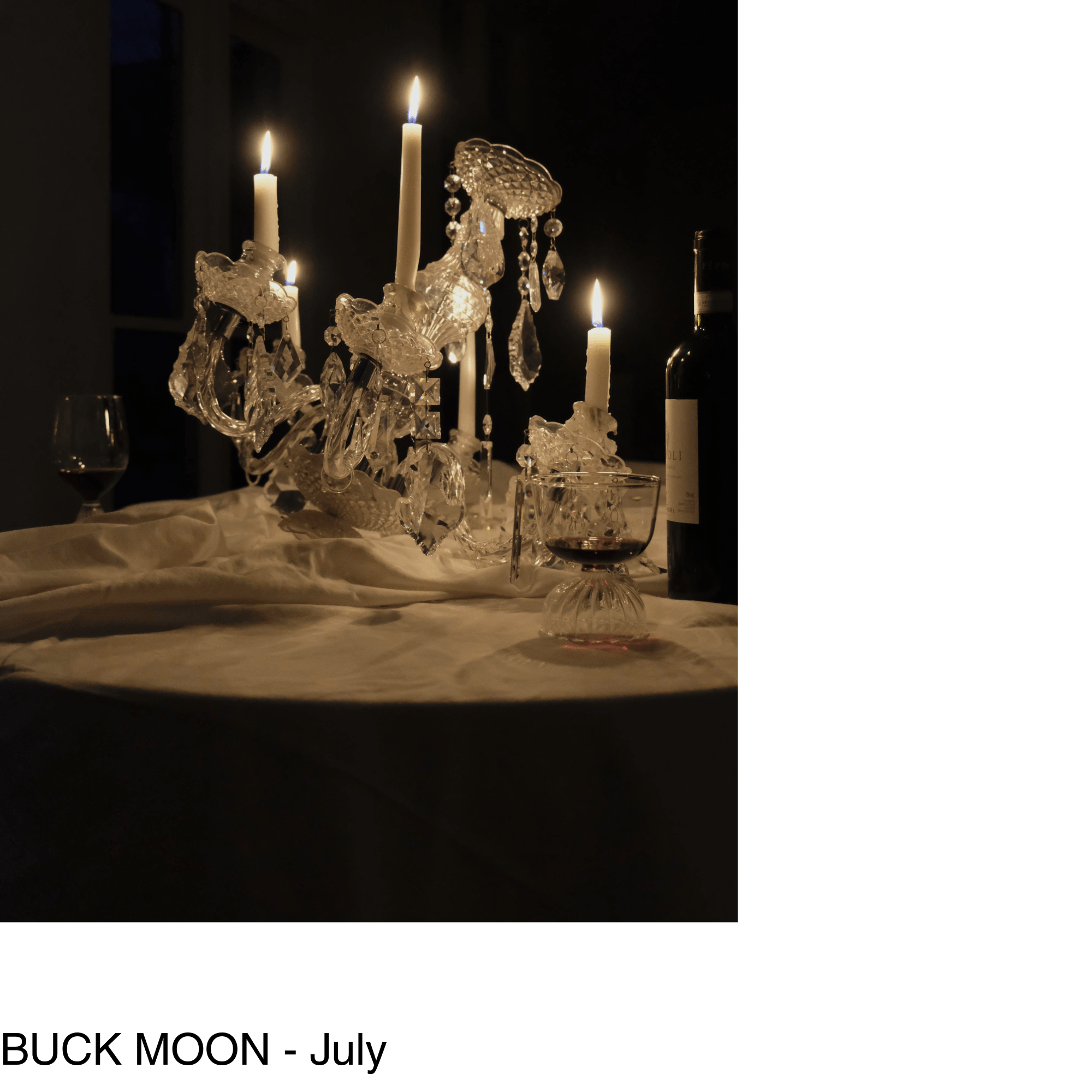 a lit chandelier sits in the middle of a table surrounded by two glasses and a bottle of wine