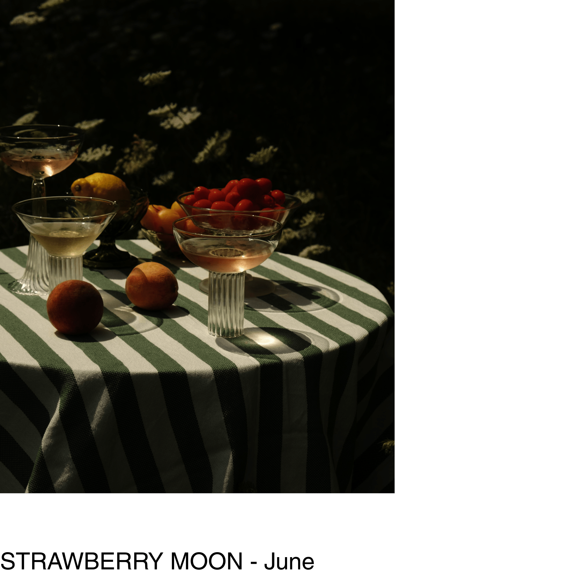 A series of cocktail glasses and various fruits sit on top of a table with a green and white striped tablecloth