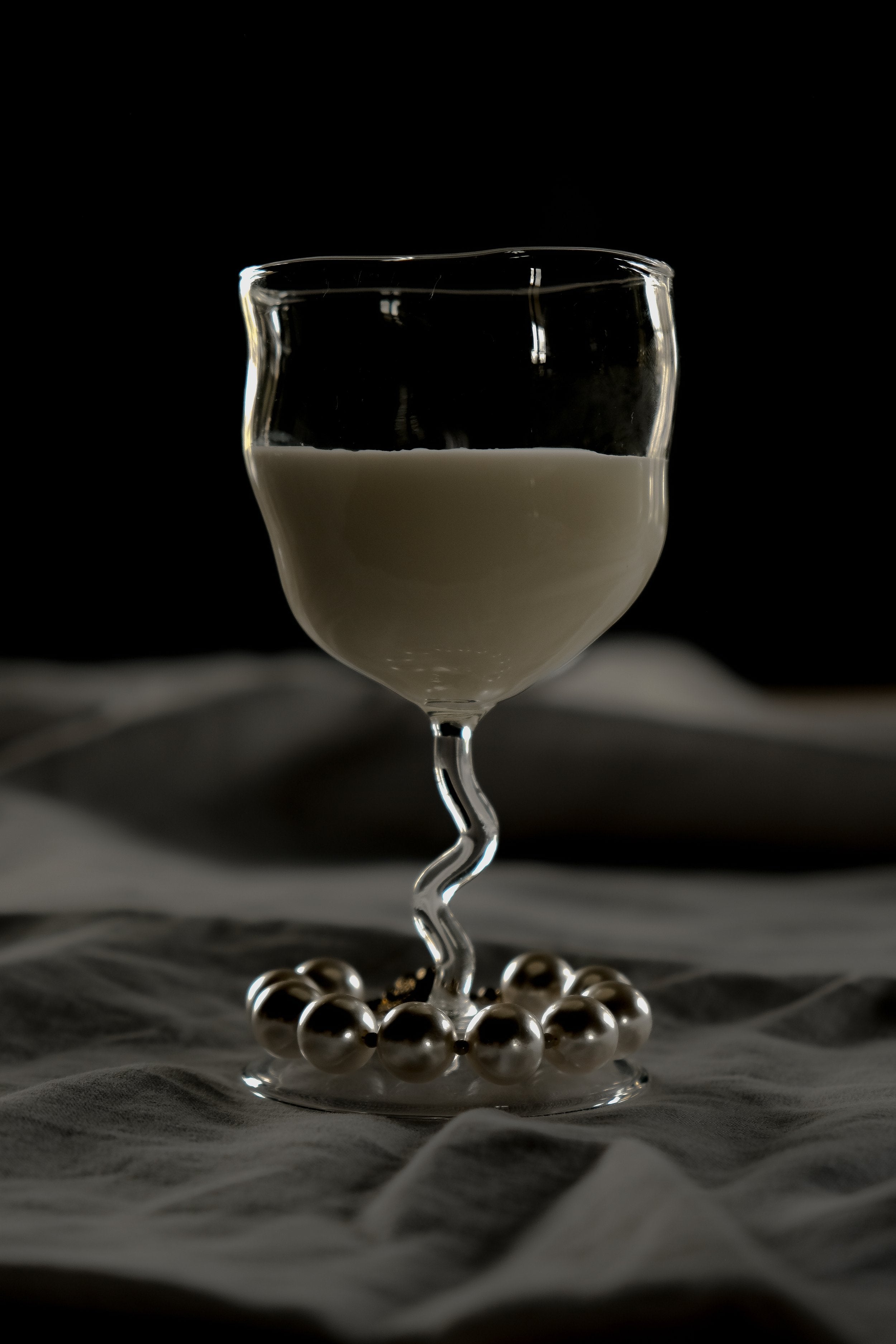 hand pressed wine glass with a fluid shape filled with milk