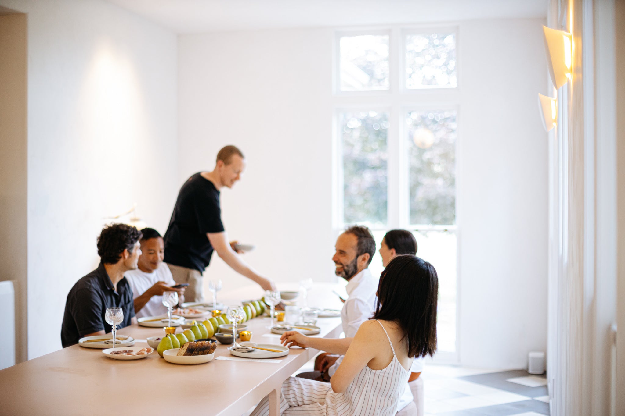 guests seated around a long dining table sharing a meal