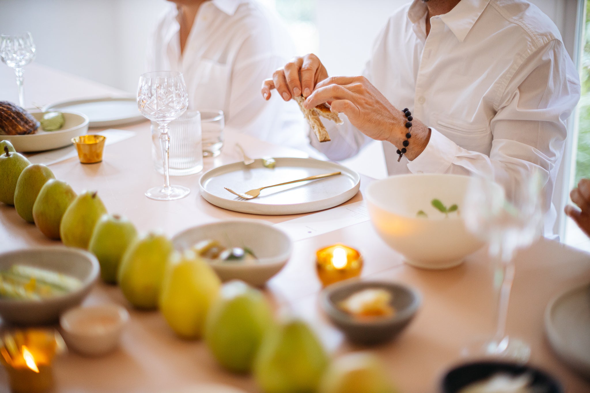 closeup of person pulling apart a piece of bread at a table