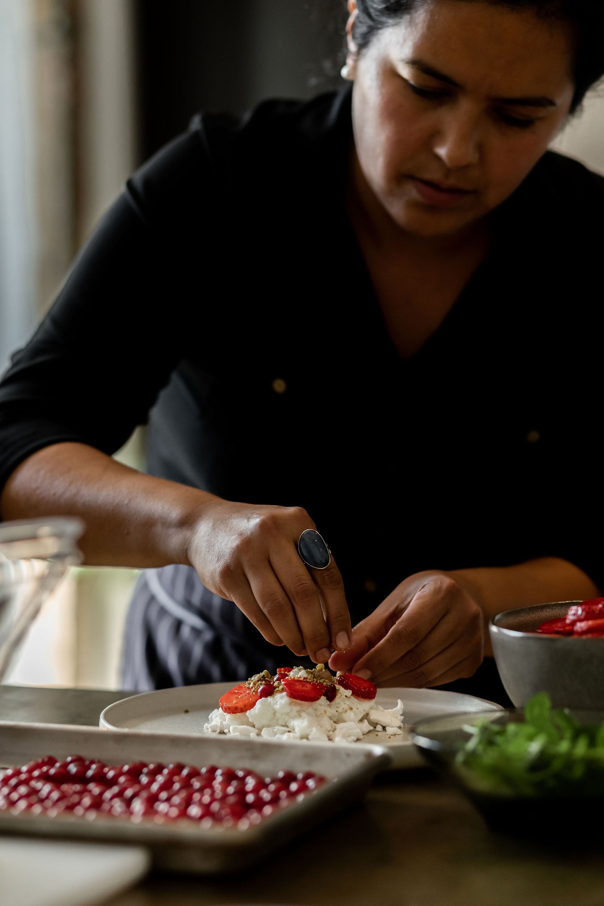 closeup of hands adding final touches to a dessert