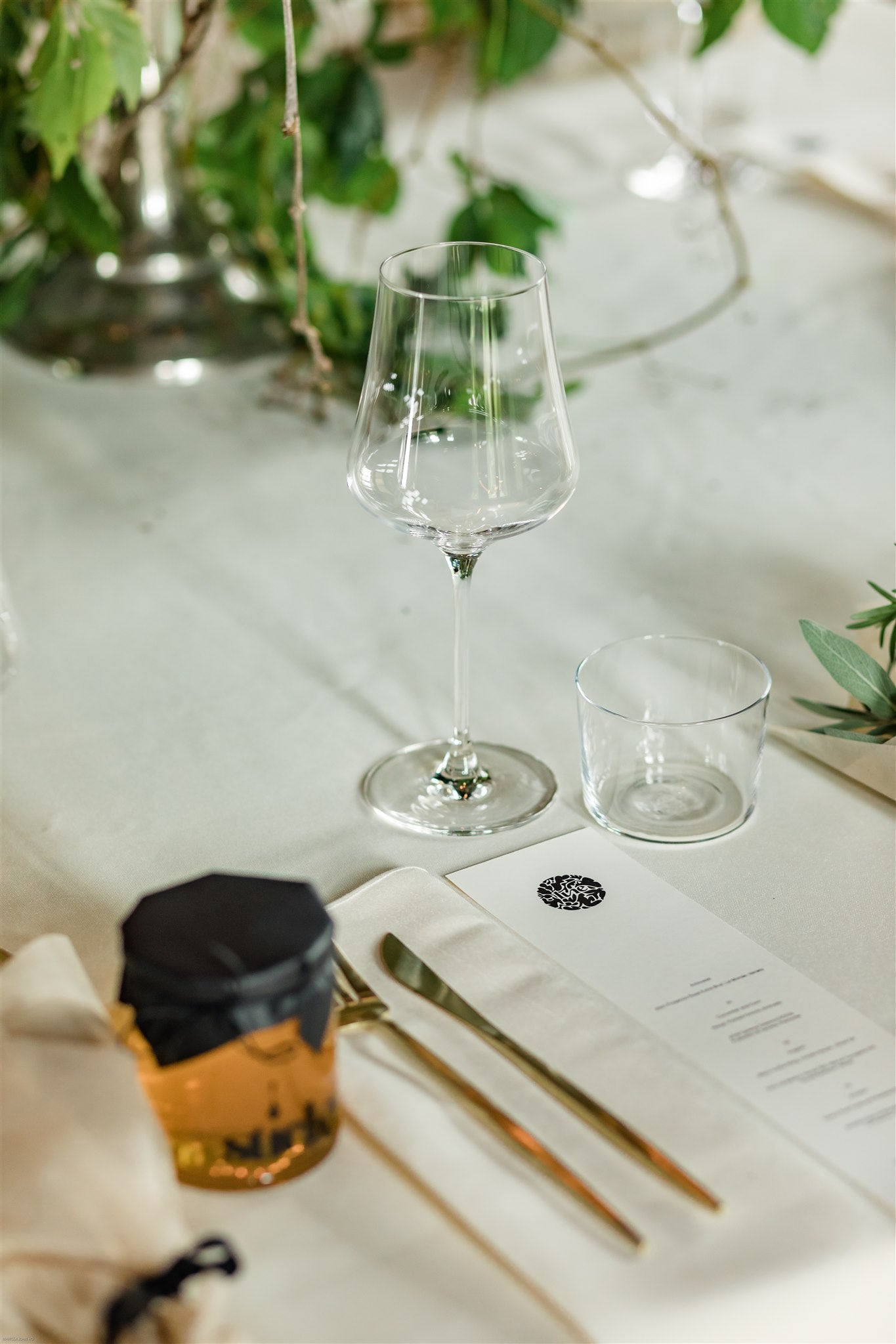 closeup of Sticky honey jar, printed menu, large wine glass