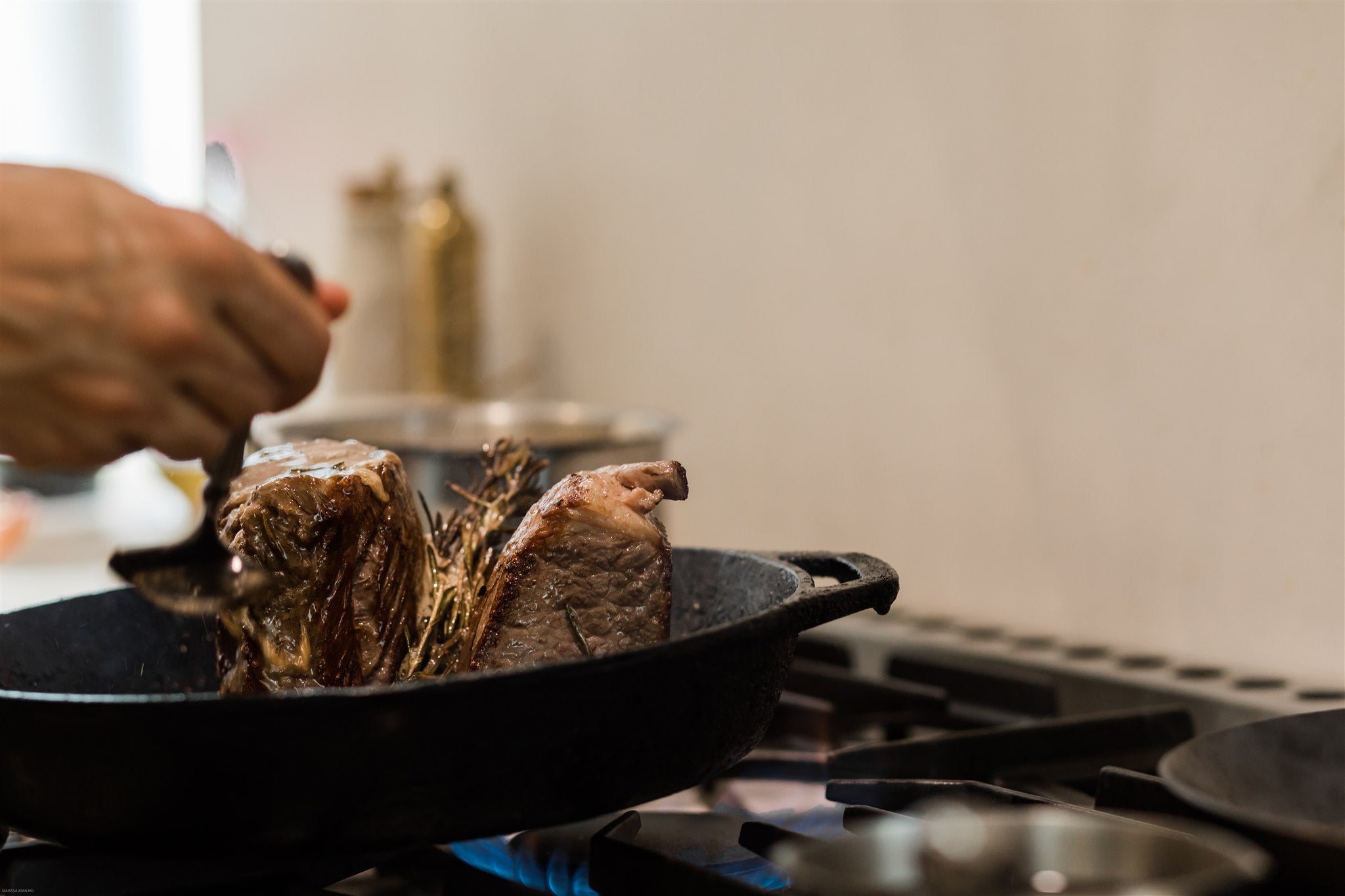 closeup of meat searing in a cast iron pan