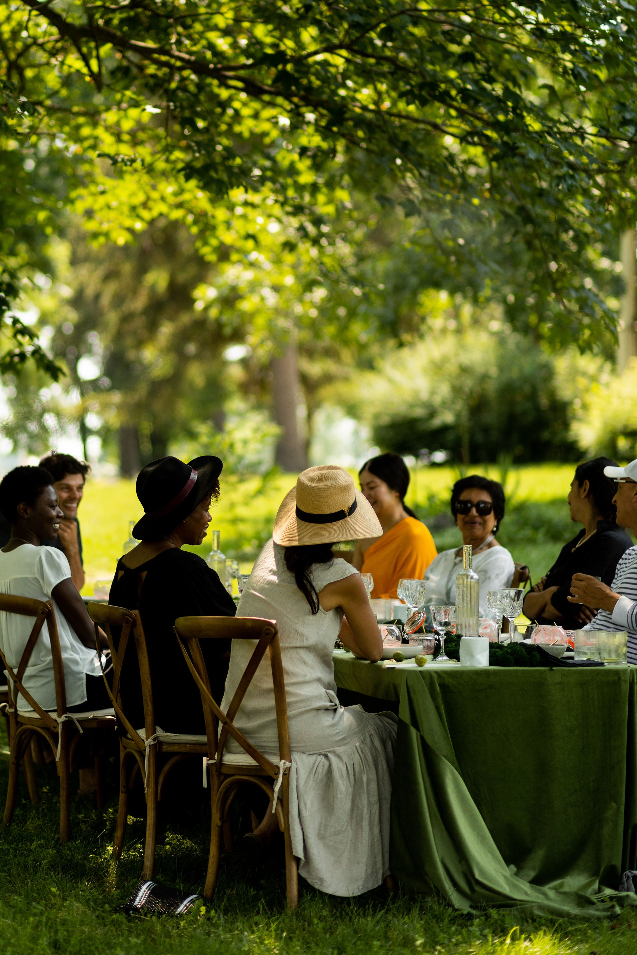 guests seated outside around a long table with a green velvet tablecloth