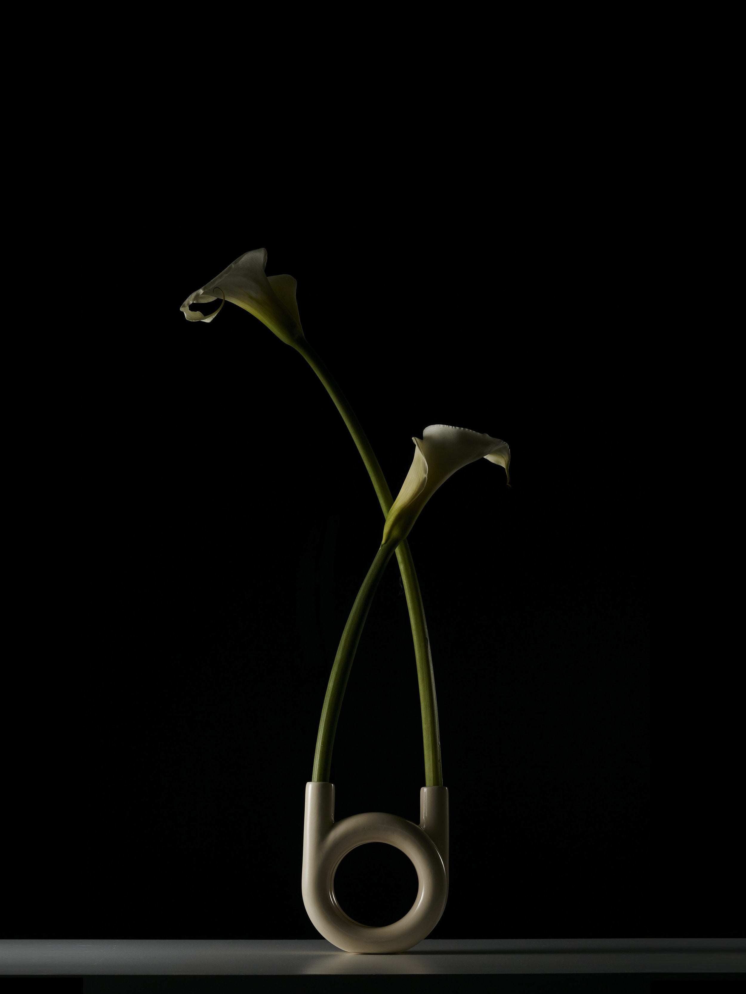 circular vase in front of black wall