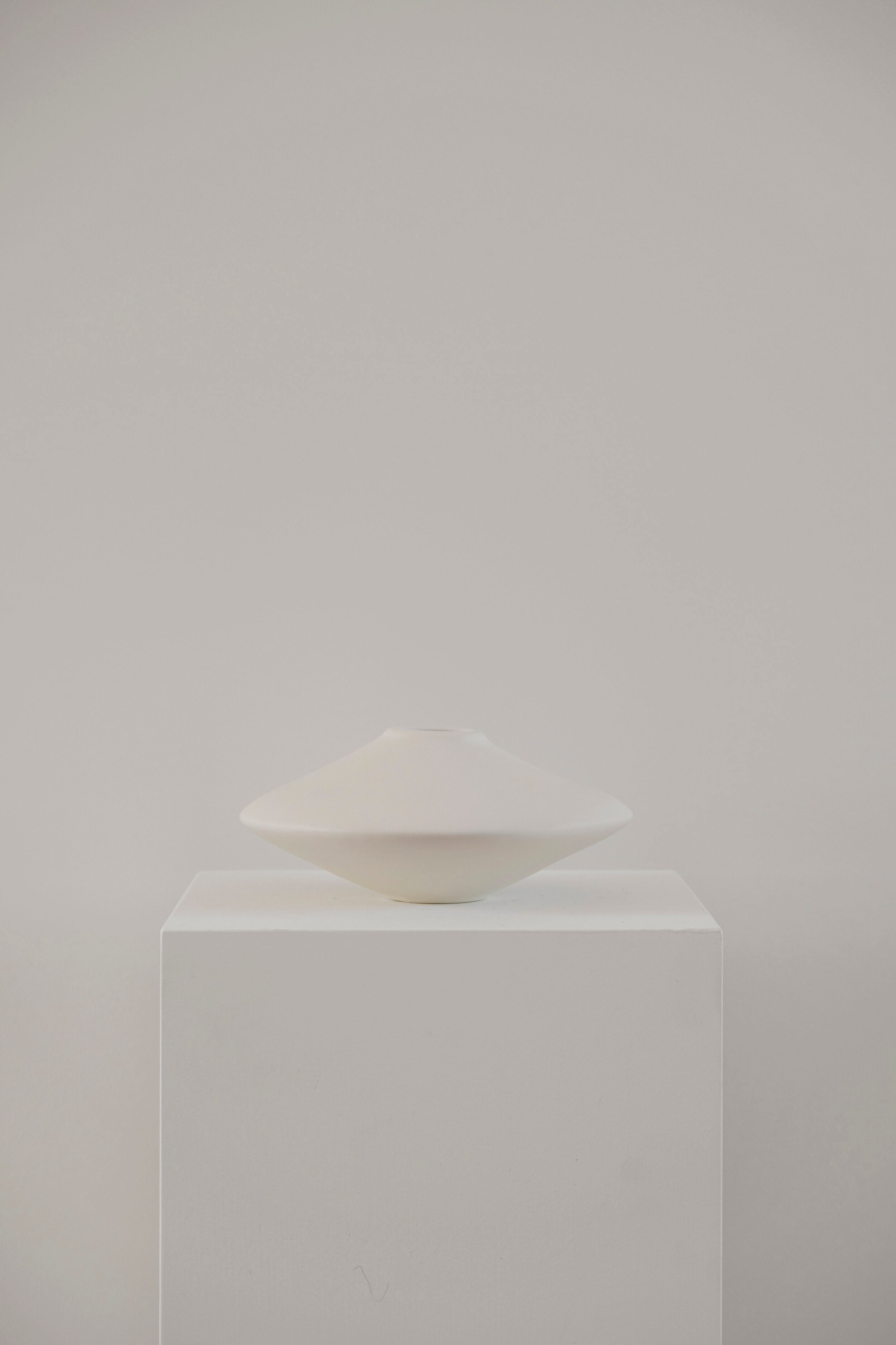 white vase on white plinth
