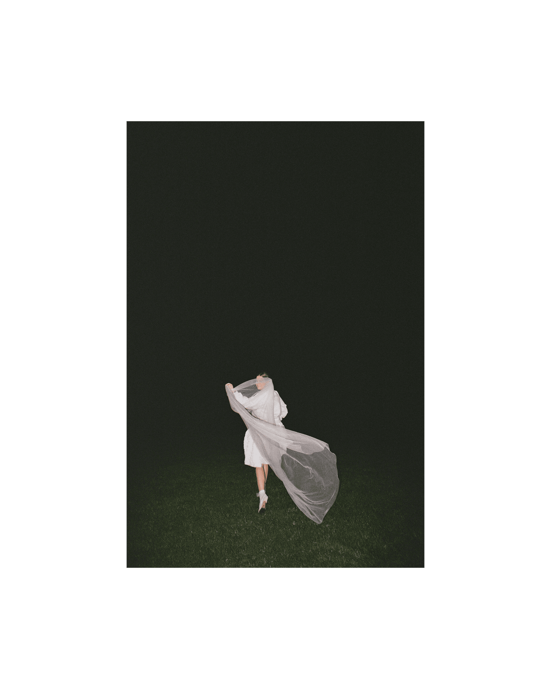 bride obscured by her veil runs off into field